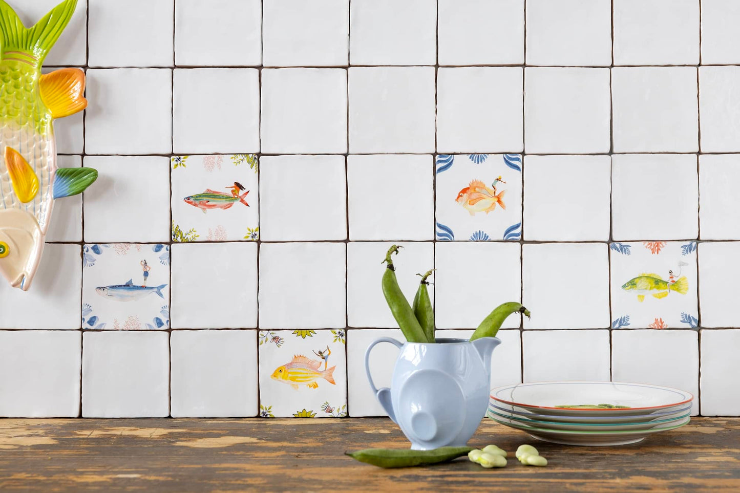 Witte tegels met kleurrijke vismotieven op keukenachtergrond