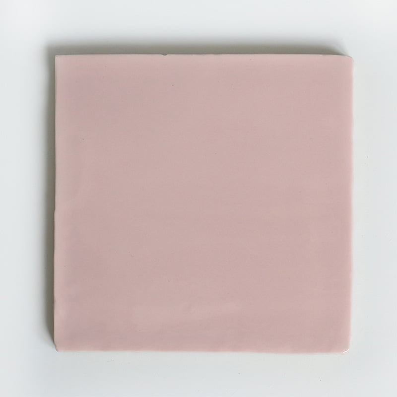 Roze vierkant tegeltje op een effen witte achtergrond geplaatst