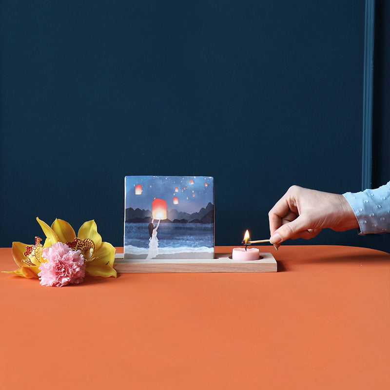 Gepersonaliseerd tegeltje met lampionnen op houten standaard met kaars