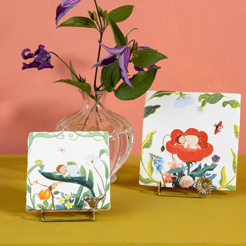 Tegeltjes met illustraties van kindjes in bloemen, kleurrijk gepresenteerd