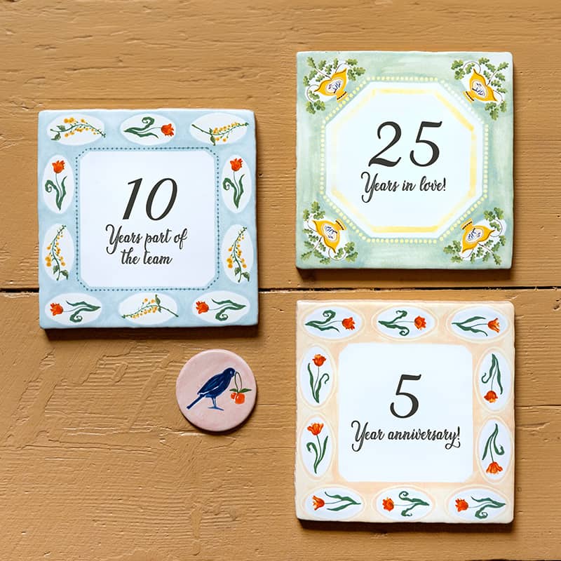 Jubileumcadeau tegeltje met bloemen en jaargetallen op tafel