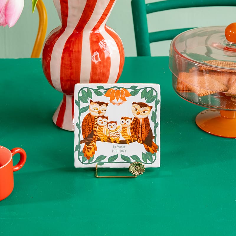 Geboortetegel met uilenfamilie op groene tafel met decoratie