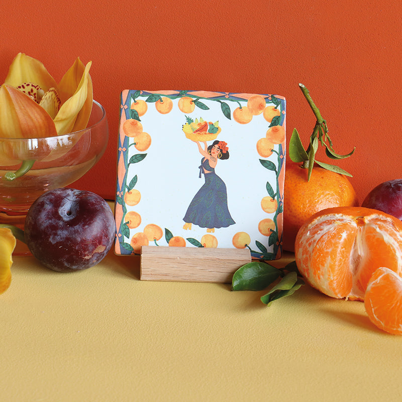 Tegeltje met vrouw en fruit, omringd door sinaasappels