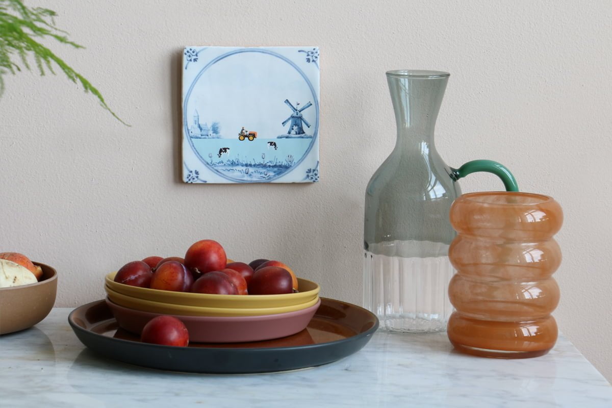 Delfts blauw tegeltje met molen en tractor, aan muur bevestigd
