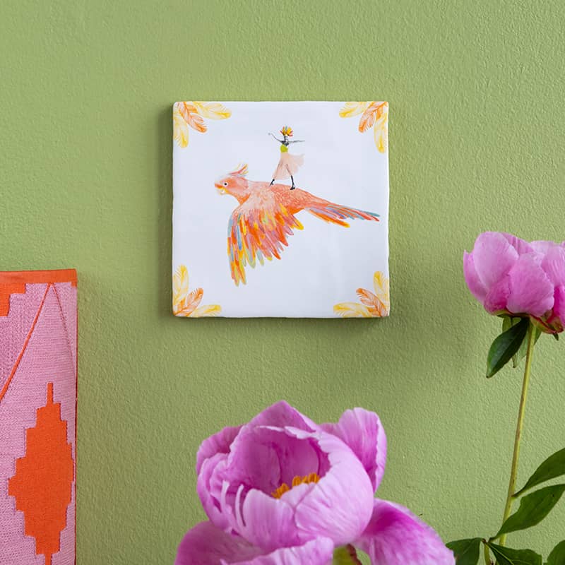 Tegeltje papegaai rijdend persoon op groene muur met bloemen