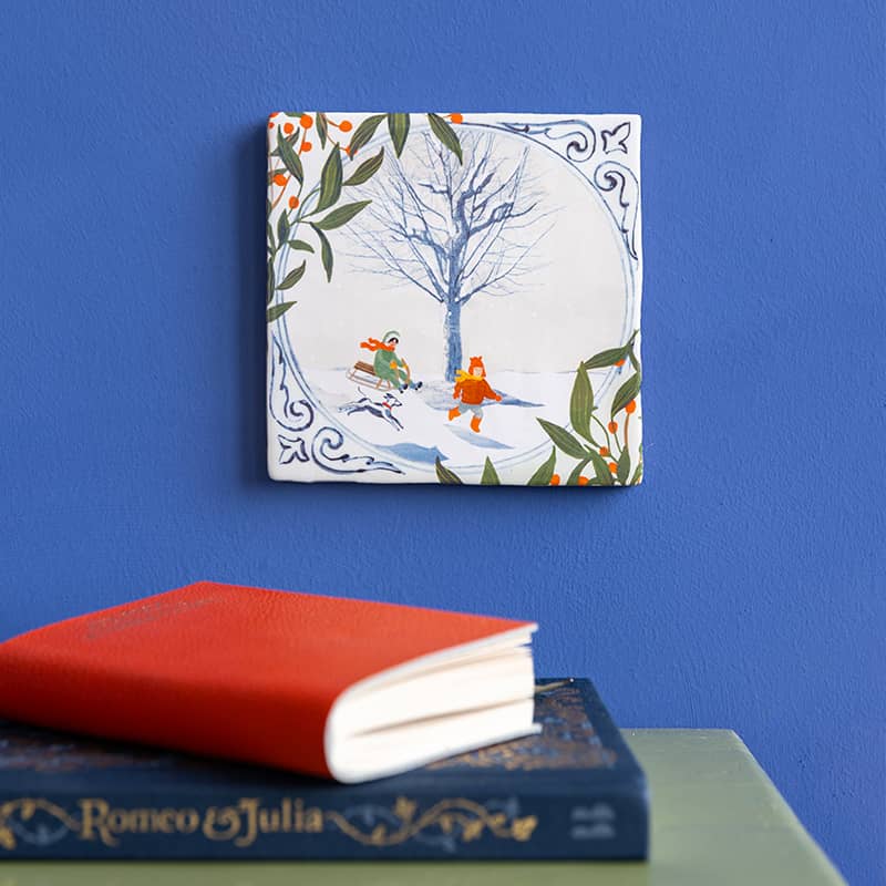 Delfts blauw tegeltje met winters tafereel, blauw achtergrond, boeken dichtbij