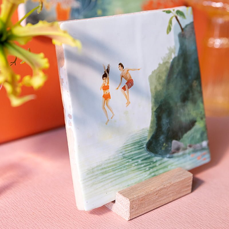 Geslaagd cadeau tegeltje met springende figuren in houten standaard