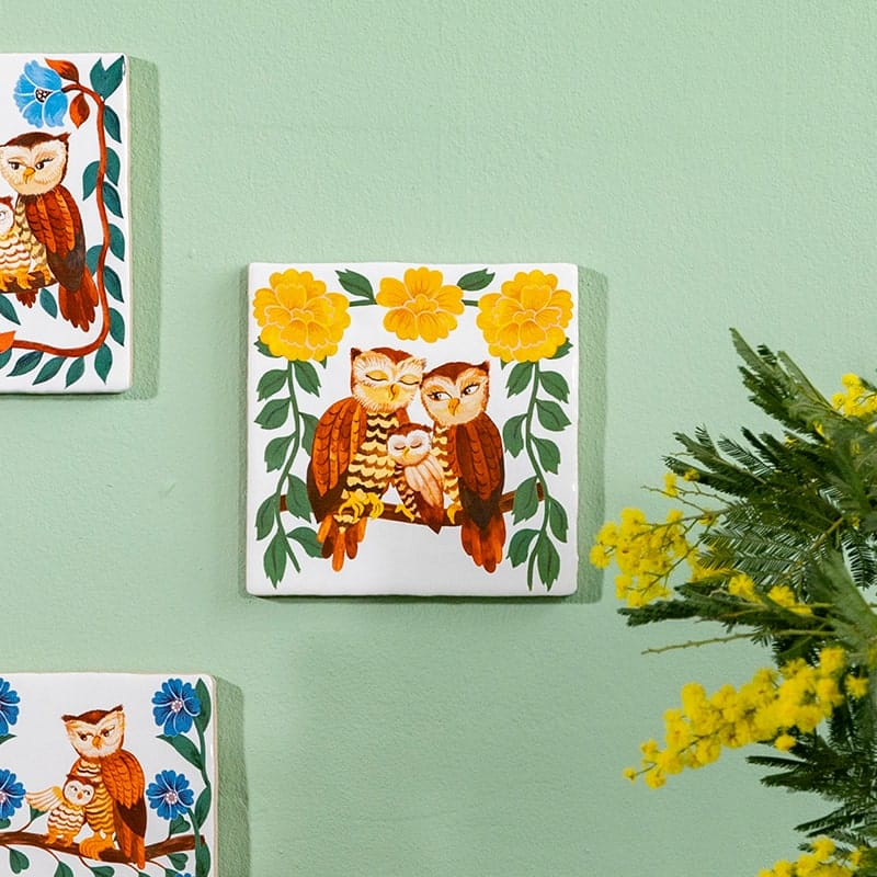 Geboortetegel uilenfamilie met gele bloemen tegen groene muur