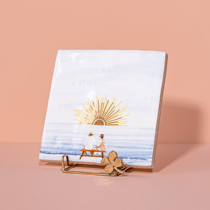 Gouden tegelhouder met een klaver en aquareltegeltje met zonsondergang