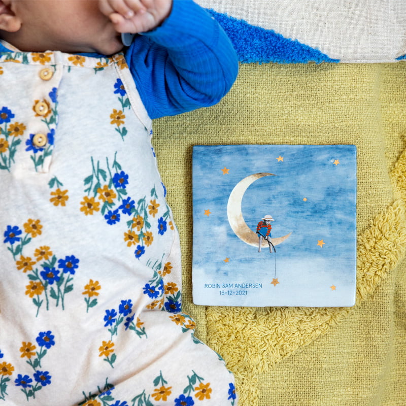 Geboortetegel kind op maan, naast baby op kleed