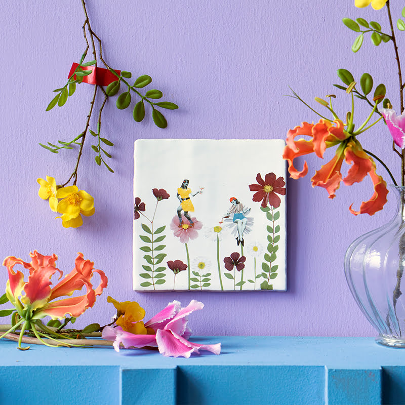 Tegeltje met bloemen en dansende figuren aan paarse muur