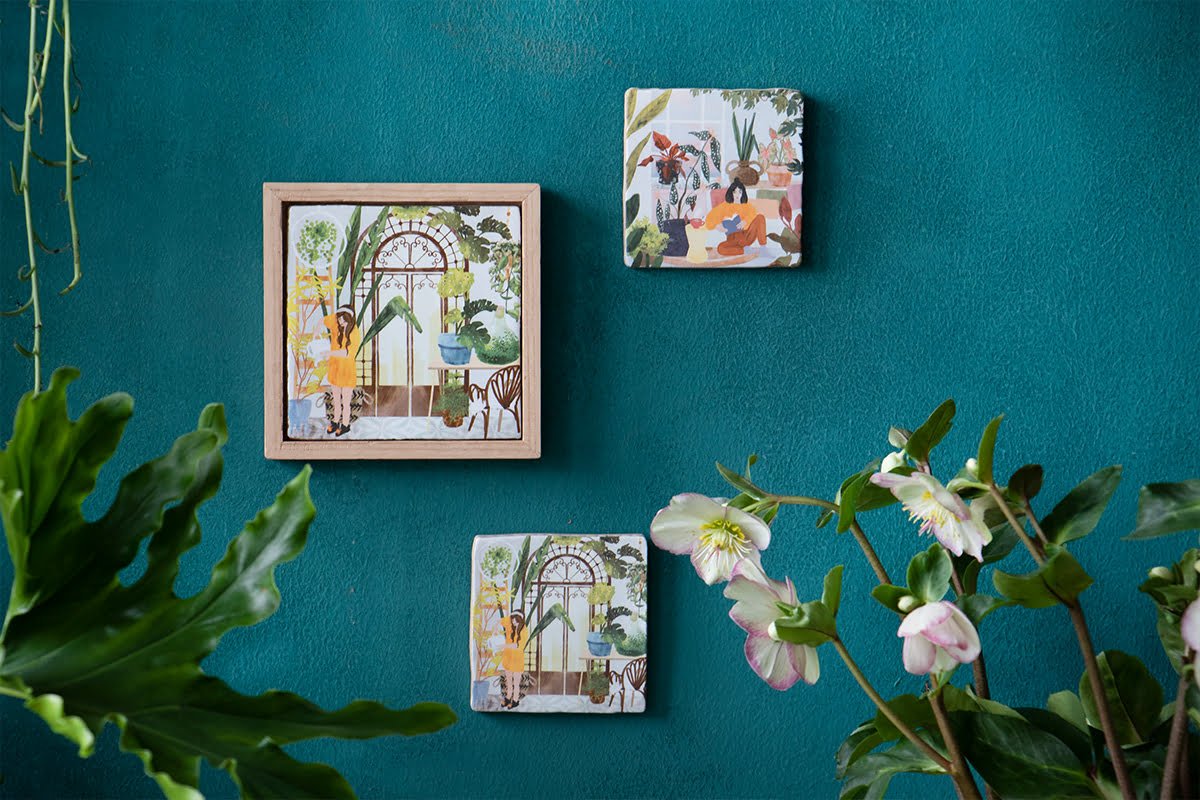 Tegeltje plantenillustraties aan groene muur met bloemen en lijst