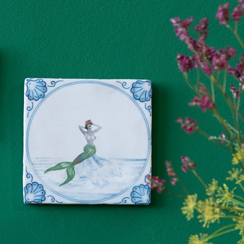 Delfts blauw tegeltje met zeemeermin op groene muur