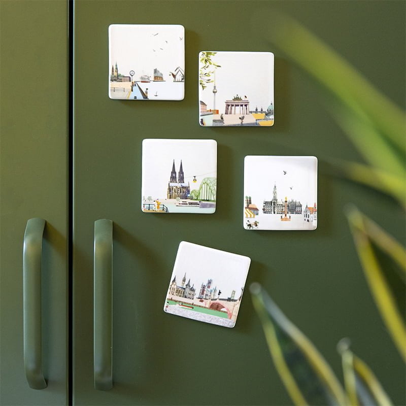 Mini tegeltje stadsillustraties op groene koelkastdeur bevestigd