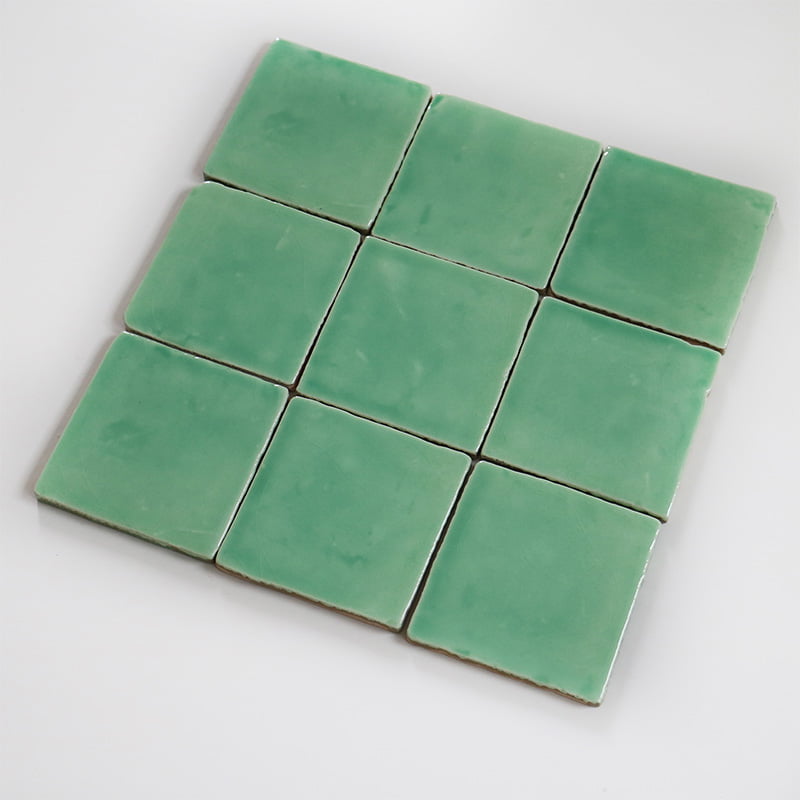 Groene vierkante tegels liggen in een grid op wit oppervlak
