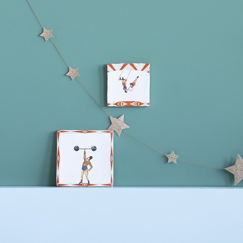 Tegeltjes met acrobaten en gewichtheffer aan groene muur