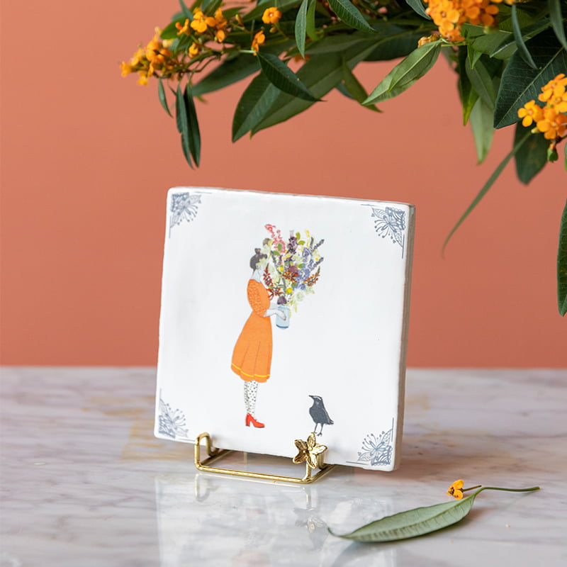 Gouden tegelhouder met bloemmotief op marmeren tafel