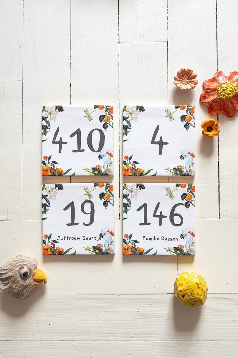Huisnummer tegeltje met bloemen en vogel op houten achtergrond