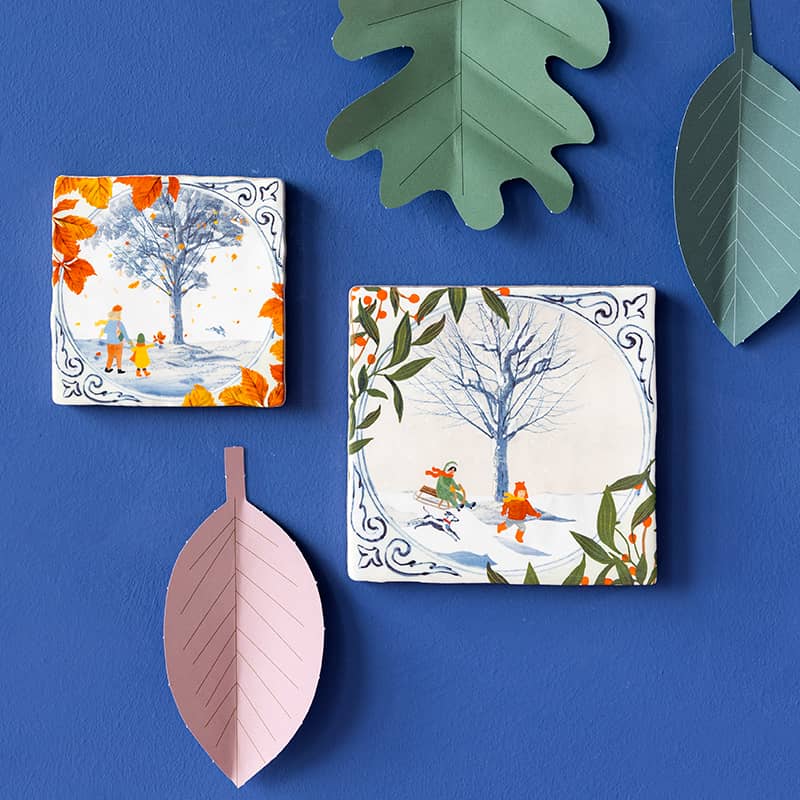 Delfts blauw tegeltje met kinderen in herfstlandschap, tegen blauwe muur