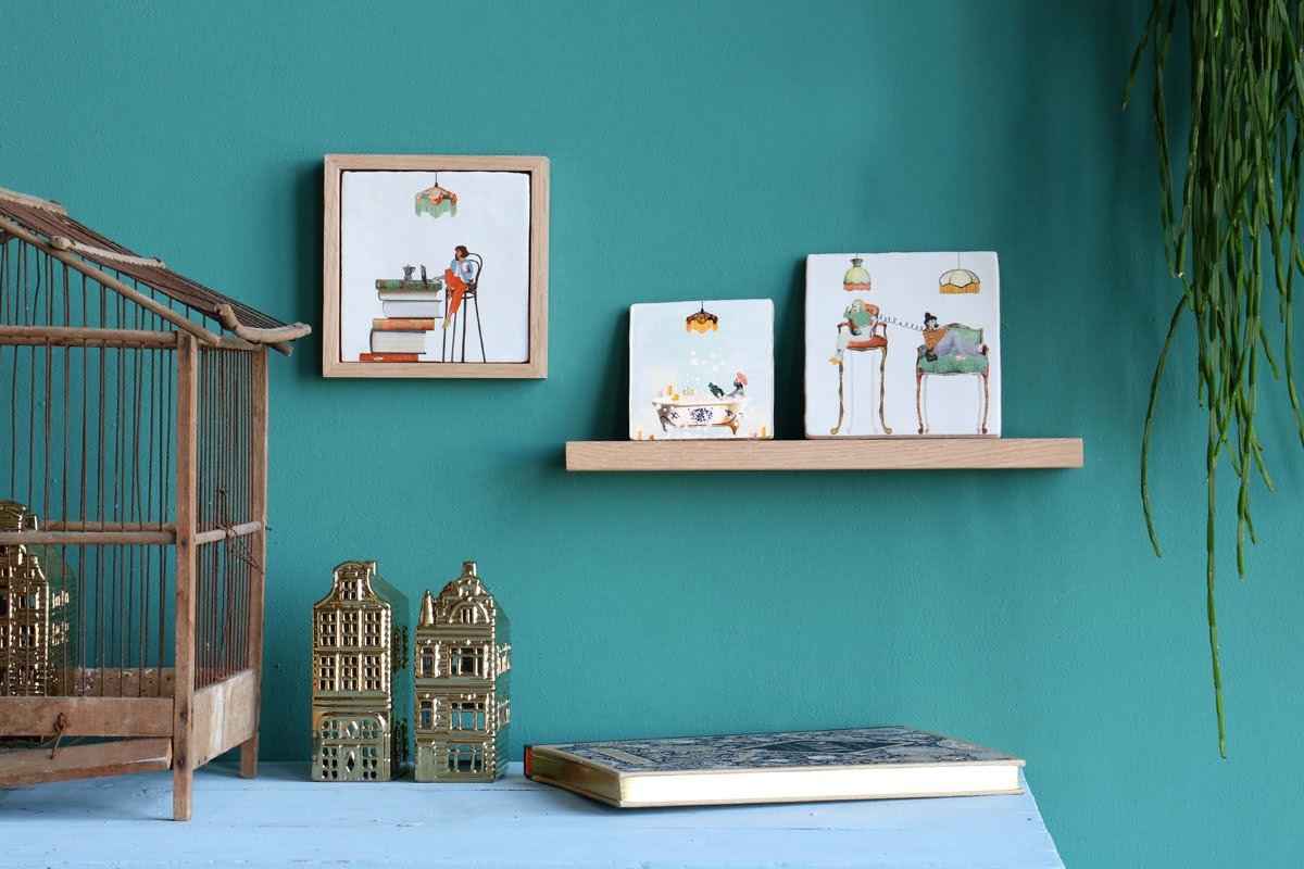 Tegeltje wanddecoratie aan turquoise muur met houten plank