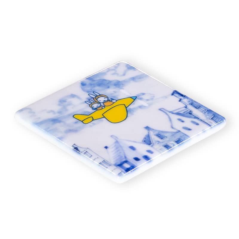 Mini tegeltje Nijntje in vliegtuig boven huisjes in lucht