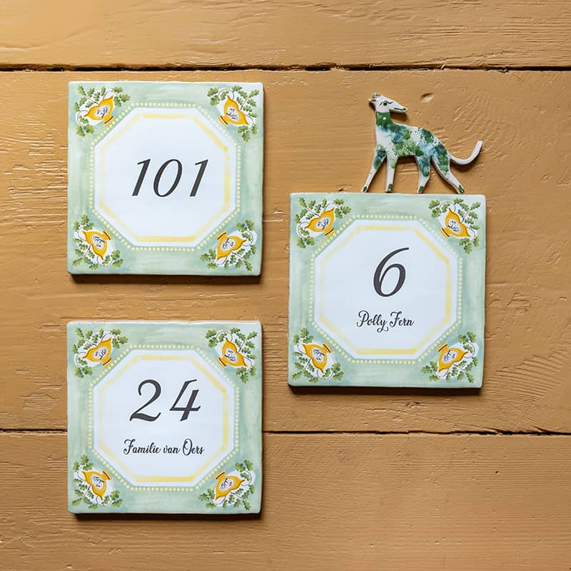 Huisnummer tegeltje met gele bloemen, groene rand en hondje