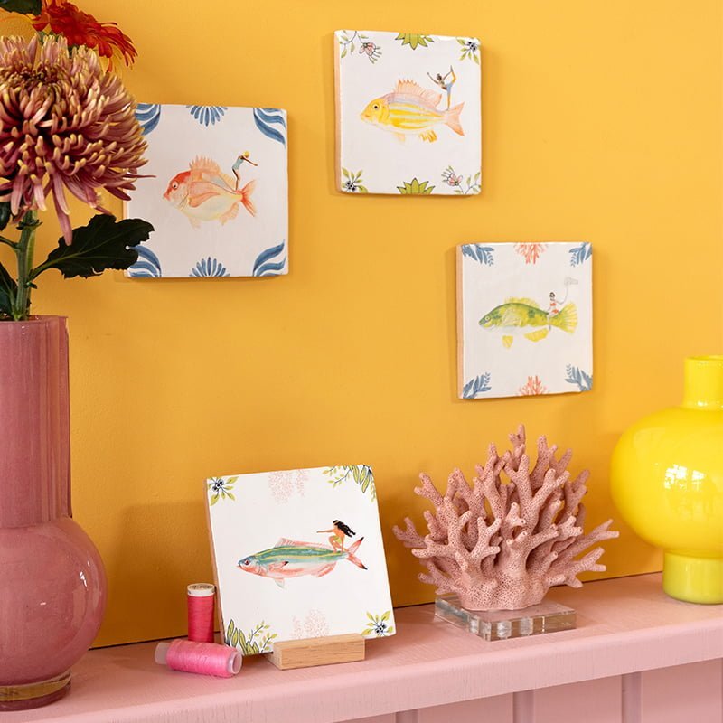 Tegeltje vissenkunst aan wand, kleurrijke decoraties en bloemenvaas