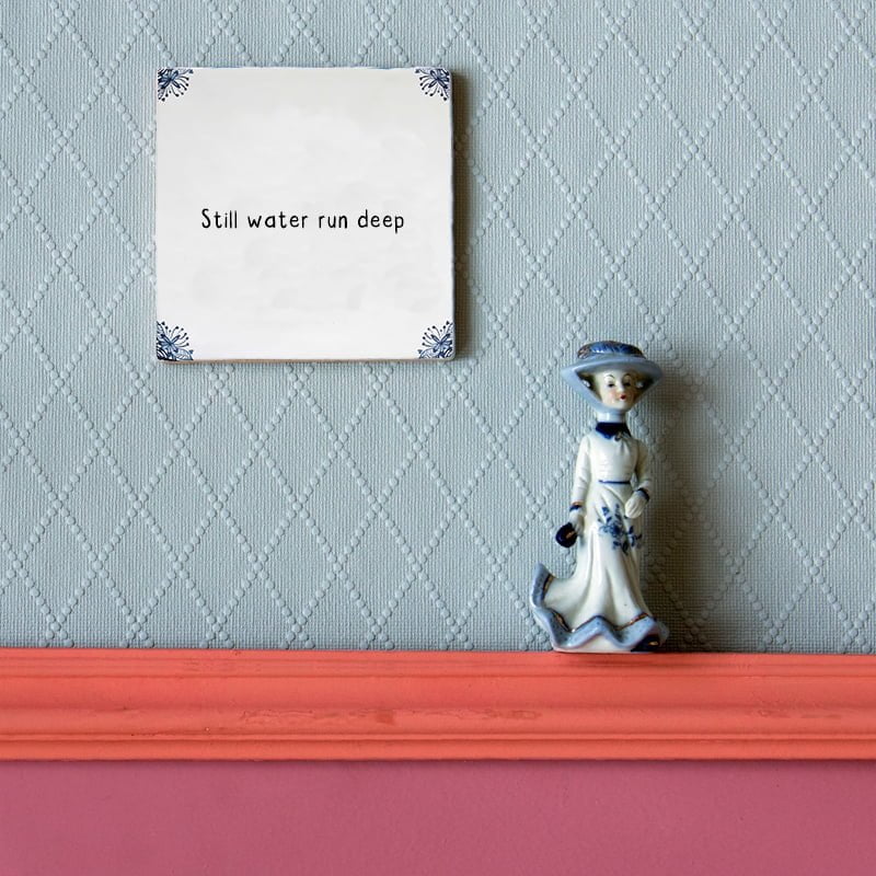 Gepersonaliseerd tegeltje met tekst, blauwe wand erachter