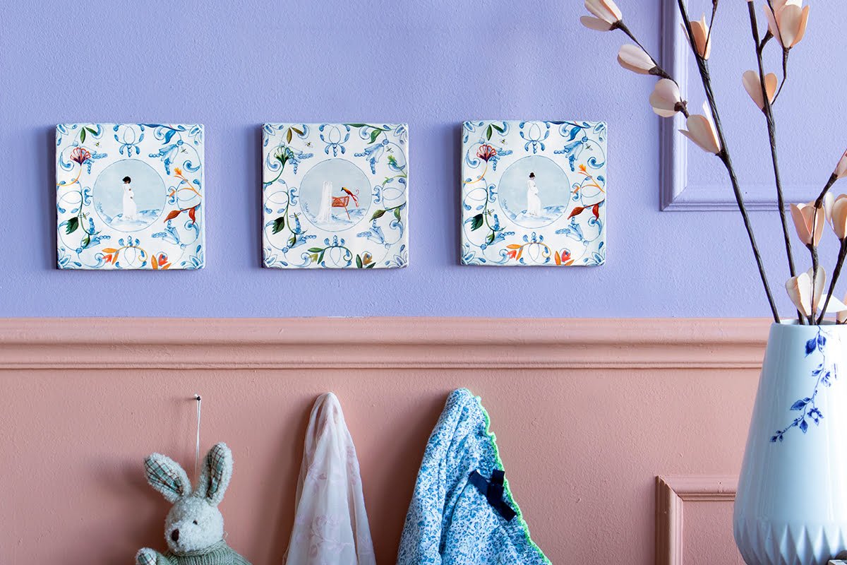 Geboortetegels met abstracte figuren aan paarse muur gepresenteerd