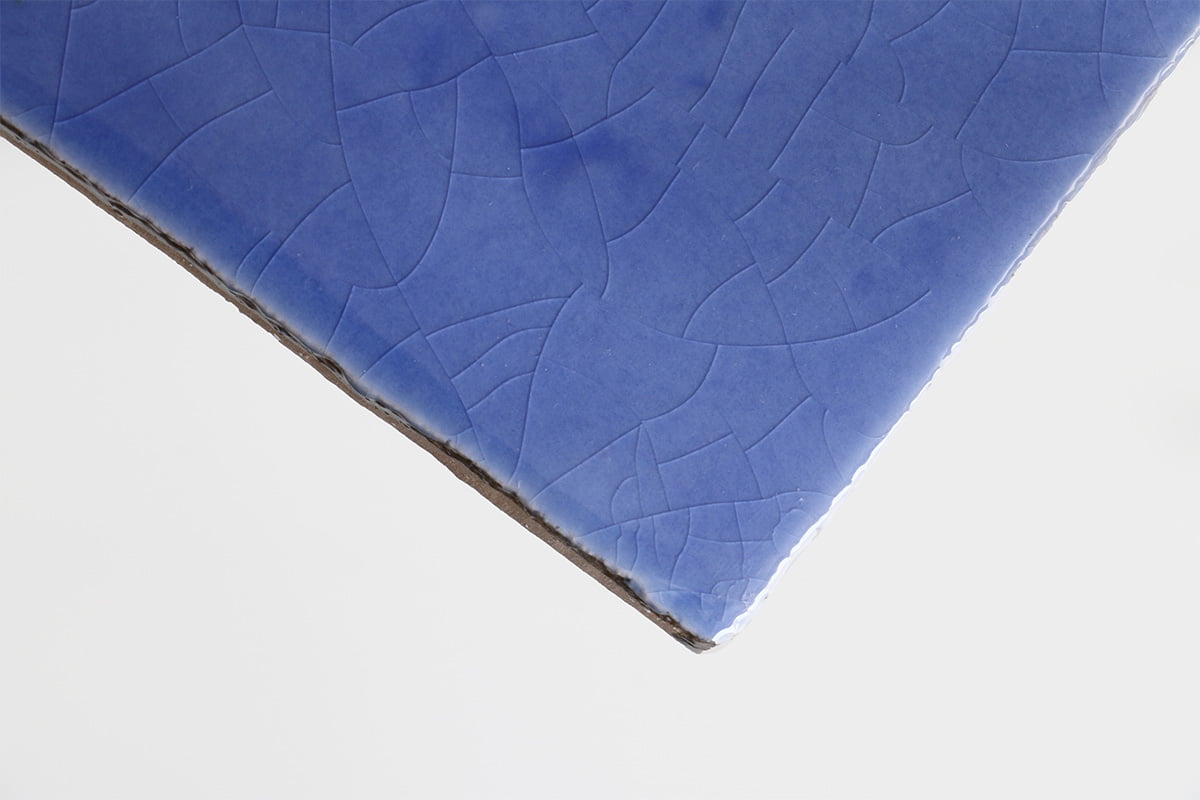 Blauw keramisch tegeltje met gebroken patroon, schuin gepositioneerd