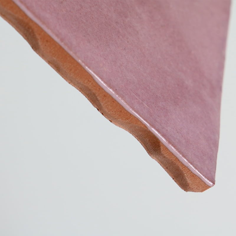 Pink keramisch tegeltje, diagonaal zwevend, tegen lichtgrijze achtergrond