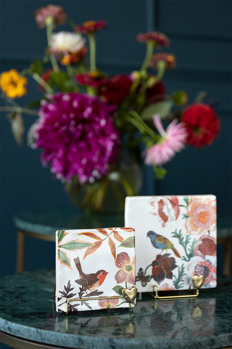 Gouden tegelhouder met hartje op marmeren tafel met bloemen