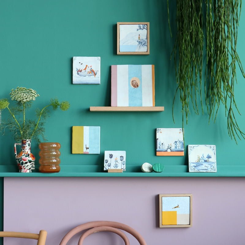 Geslaagd cadeau tegeltje diverse kunstwerken aan groene muurdisplay