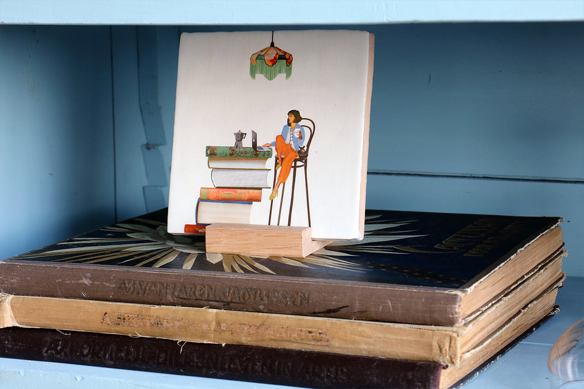 Geslaagd cadeau tegeltje persoon lezend op boeken in plank