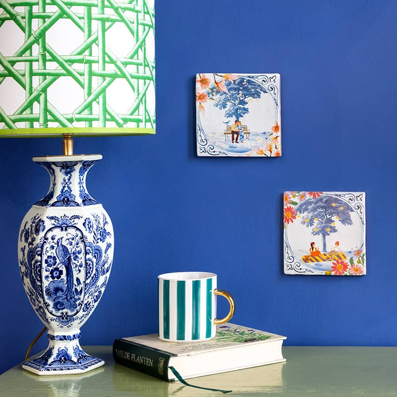 Huwelijkscadeau tegeltjes met afbeeldingen, gepresenteerd aan blauwe muur