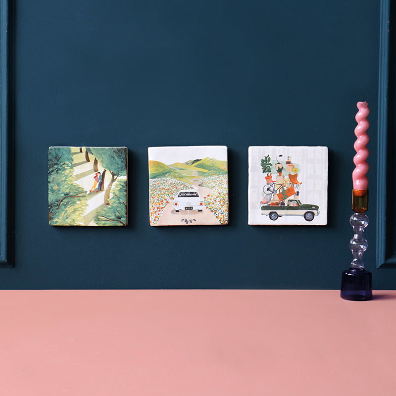 Huwelijkscadeau tegeltjes met illustraties aan blauwe muur gepresenteerd