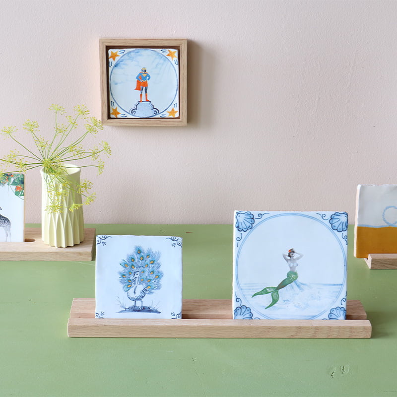 Delfts blauw tegeltje met zeemeermin op houten standaard gepresenteerd