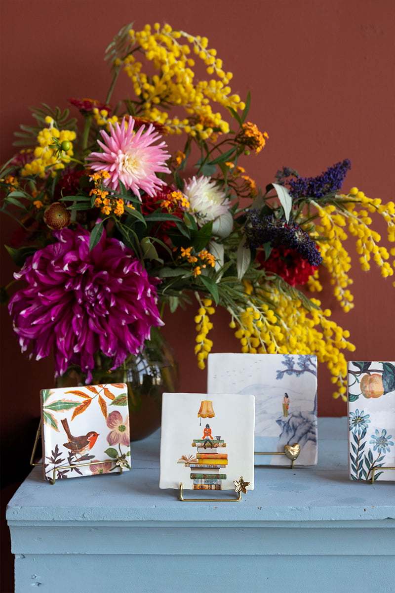 Gouden tegelhouder met hartje op blauwe tafel voor bloemenboeket