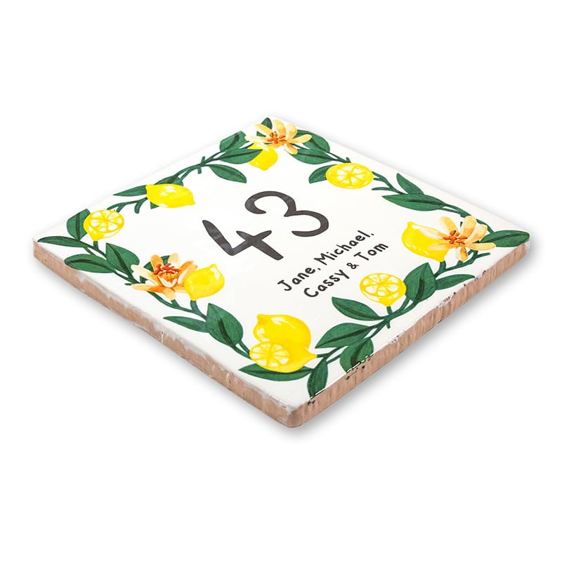 Huisnummer tegeltje met gele bloemen en groene bladeren versierd