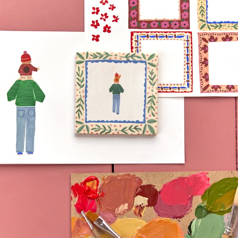 Tegeltje kind op schouders ouder tussen schildermaterialen en ontwerpen
