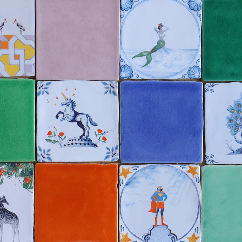 Delfts blauw tegeltje met eenhoorn tussen kleurrijke vierkante tegels