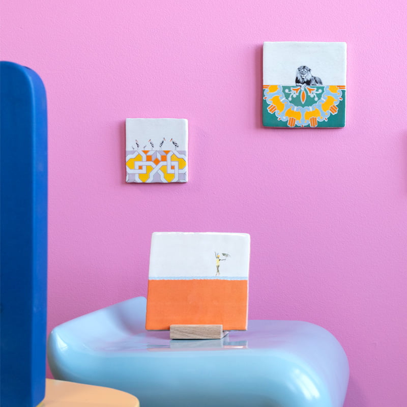 Tegeltje kleurrijke kunsttegels aan roze muur en blauwe tafel