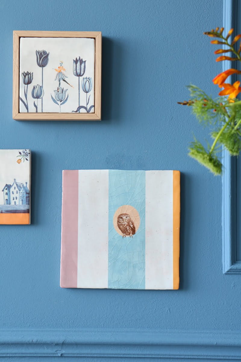 Tegeltje met tulpillustratie in houten lijst aan muur
