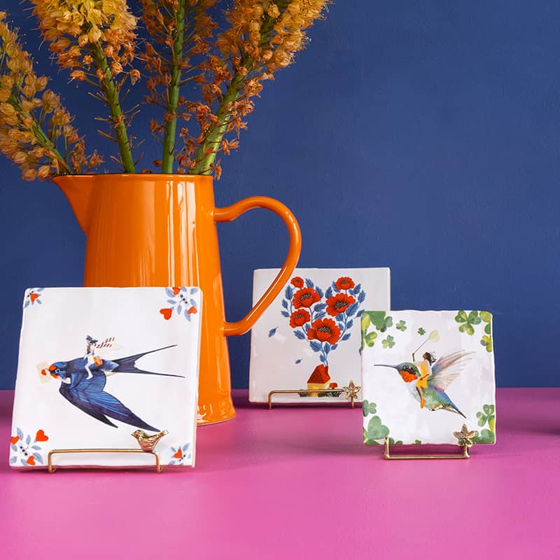 Tegeltjes met vogels en bloemen tegen blauwe achtergrond