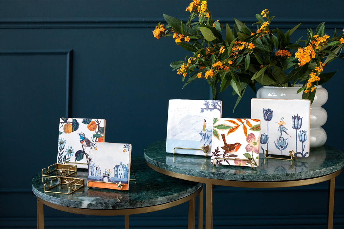 Gouden tegelhouder op een groene marmeren tafel met bloemen