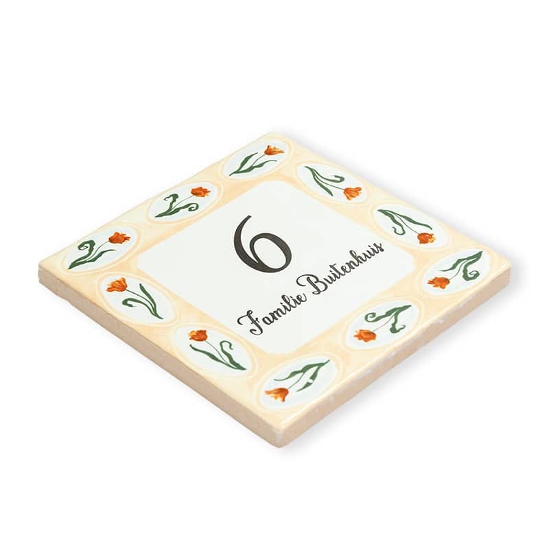 Huisnummer tegeltje versierd met oranje bloemen en familienaam