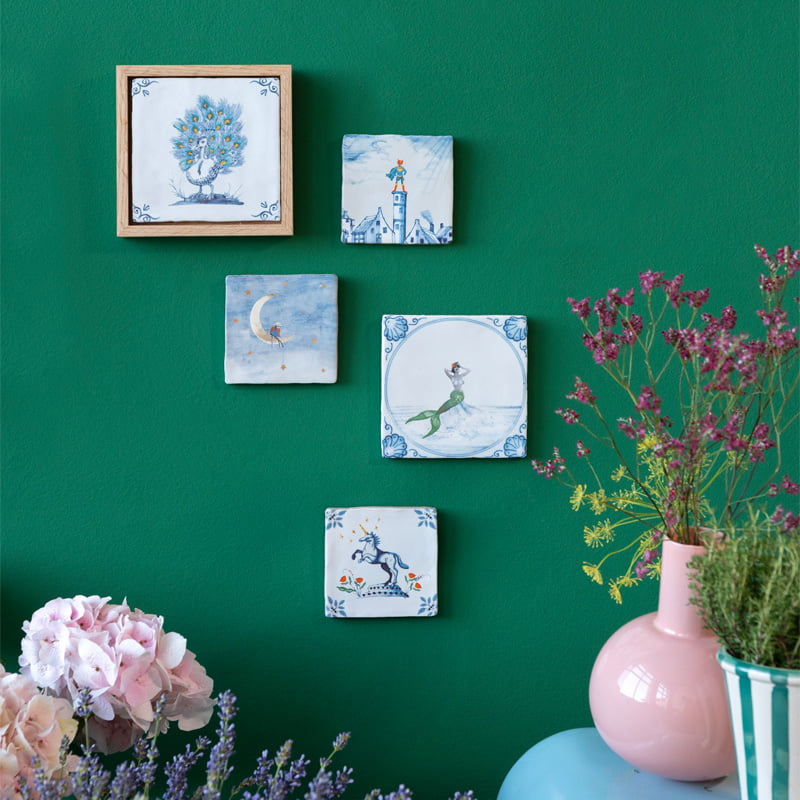 Geboortetegeltjes met fantasiefiguren aan groene muur gepresenteerd