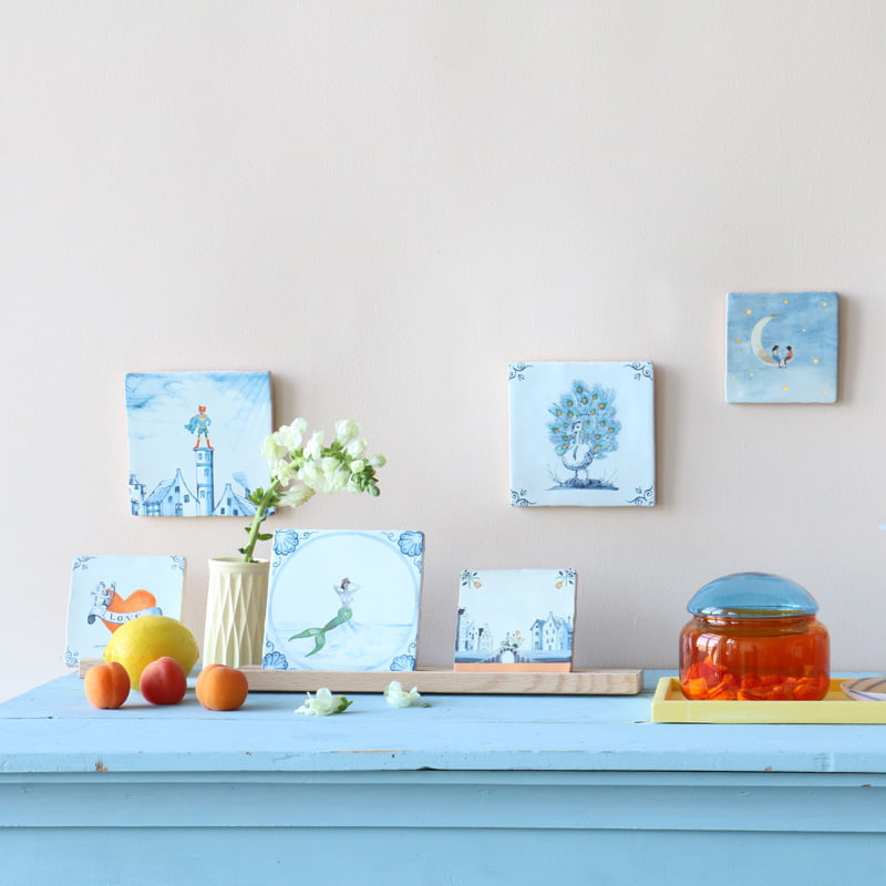 Geboortetegels met sprookjesachtige afbeeldingen op blauwe tafel gepresenteerd
