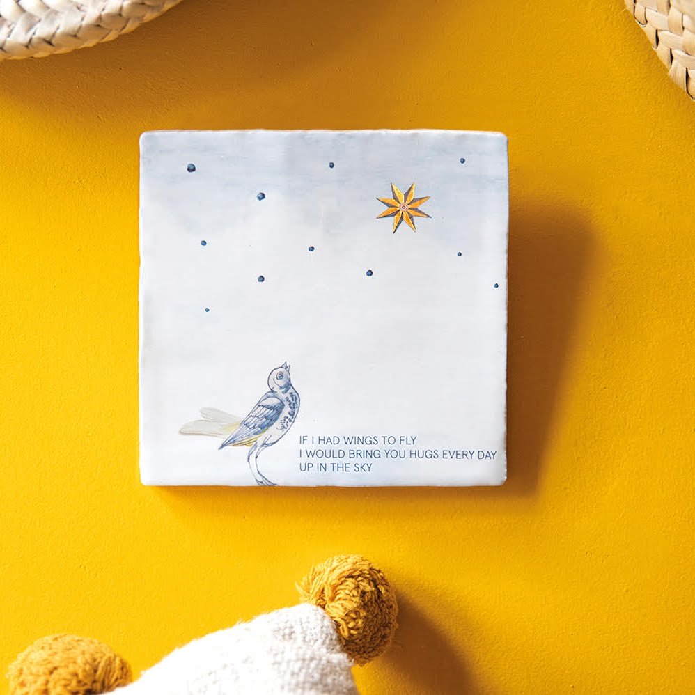 Tegeltje met vogel en ster op gele achtergrond