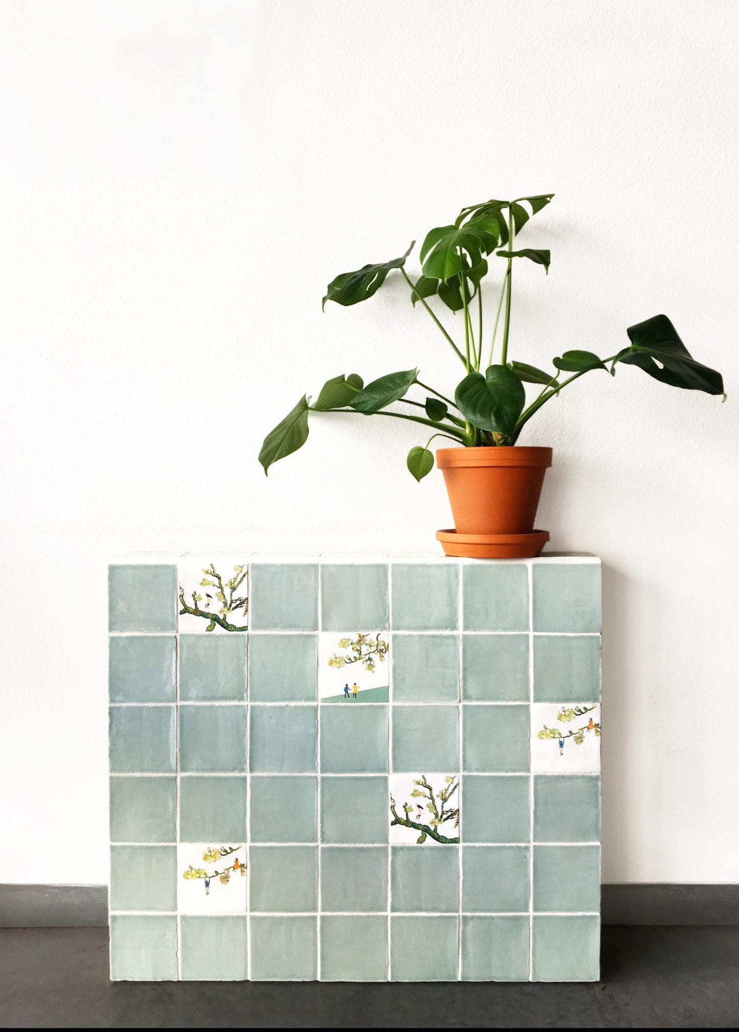 Groene plant in terracotta pot op betegelde kubus geplaatst